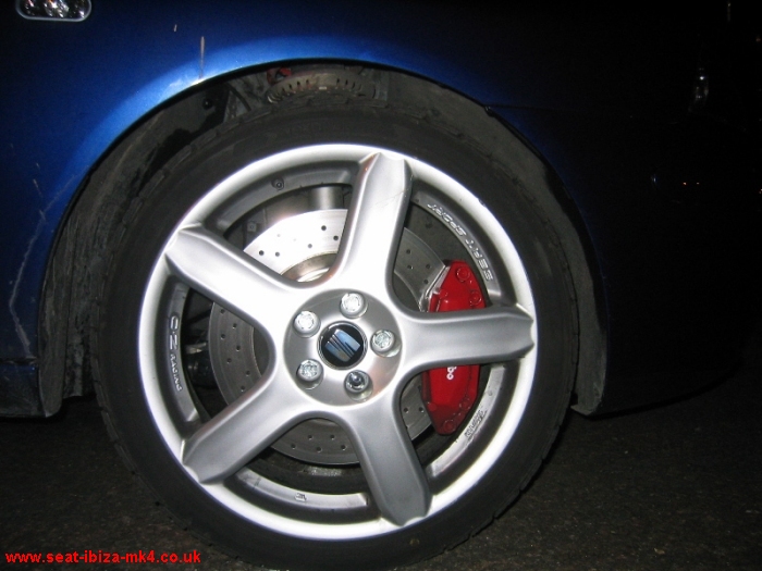 A closeup of the SeatSport 17" OZ Racing alloys, red Brembo brake calipers and drilled brake discs.